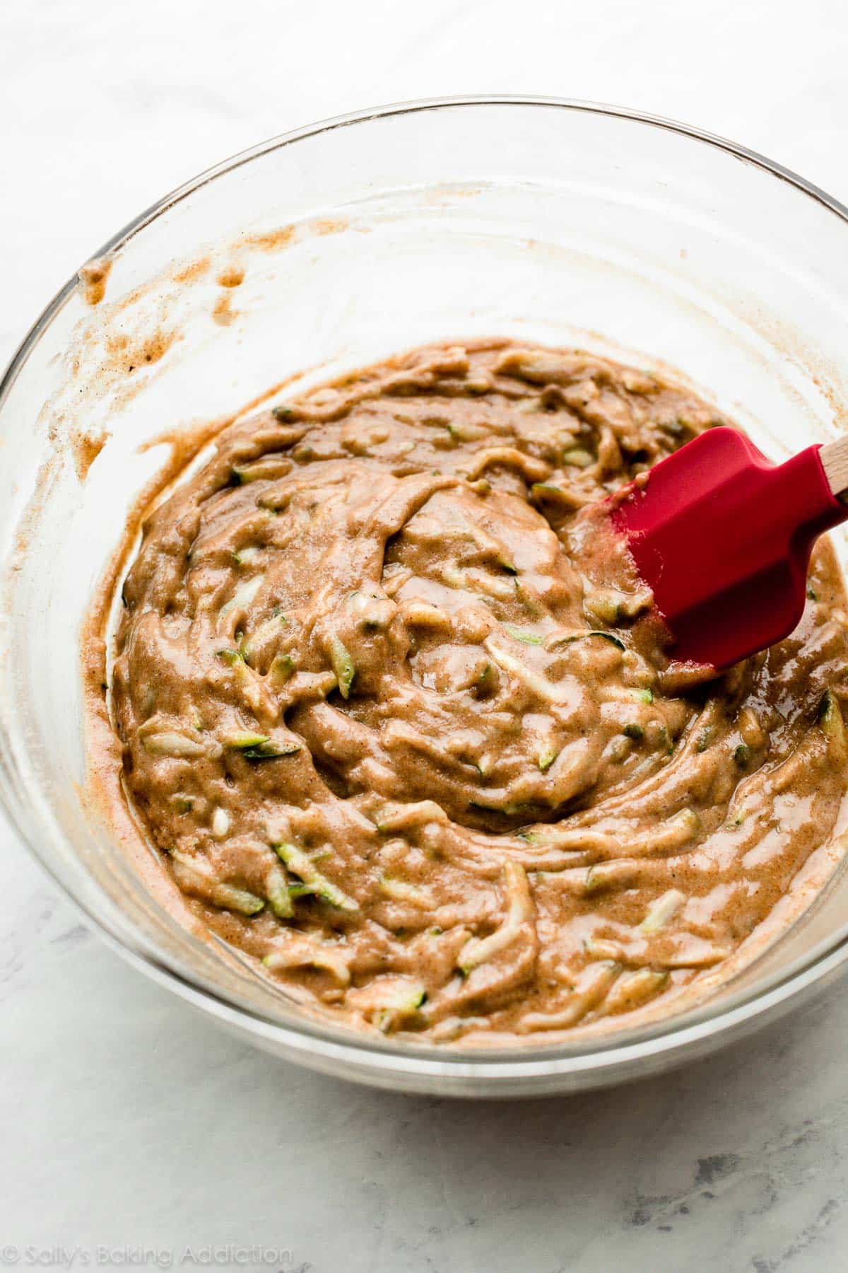 batter with shredded zucchini in glass bowl