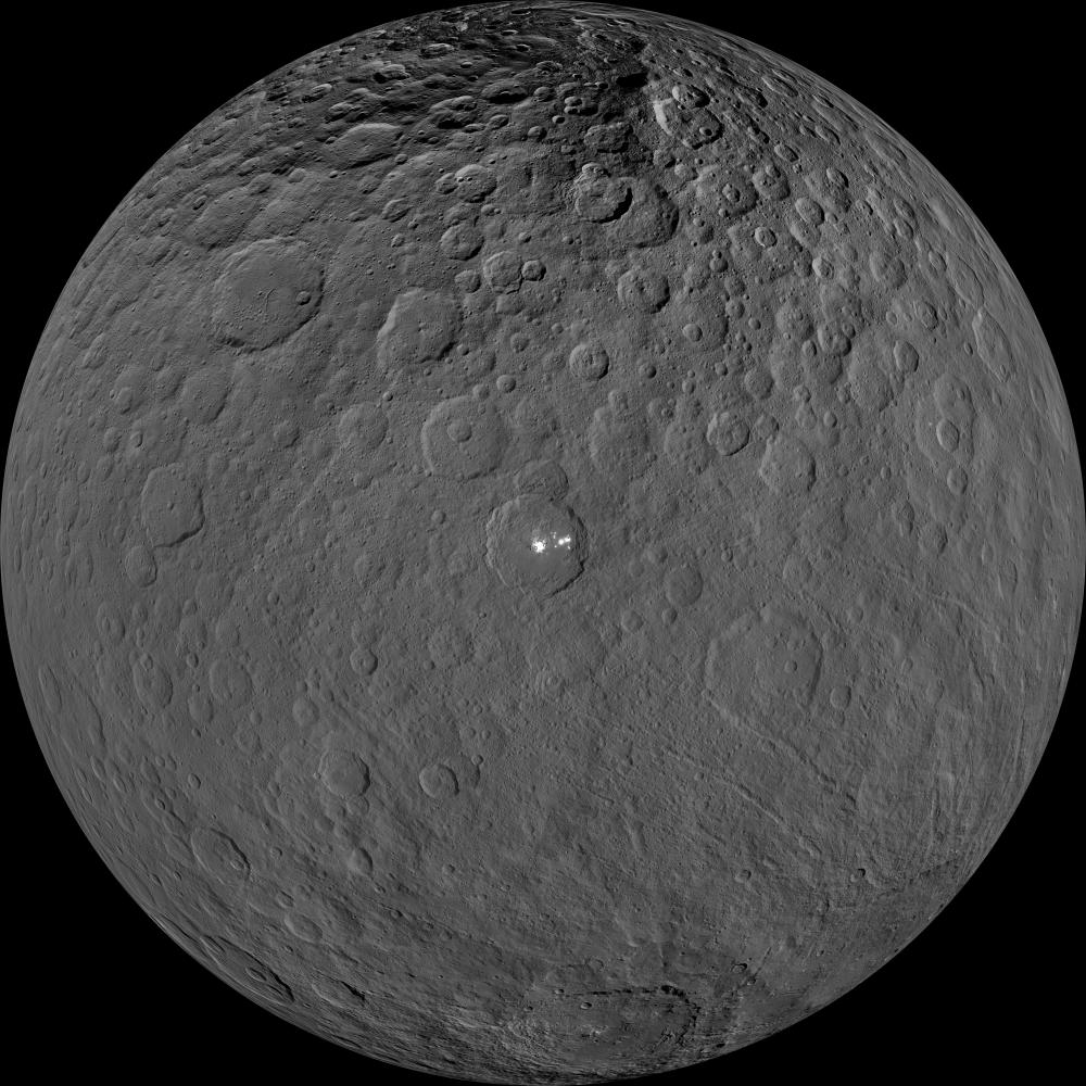 Gray dwarf planet with bright spot near center