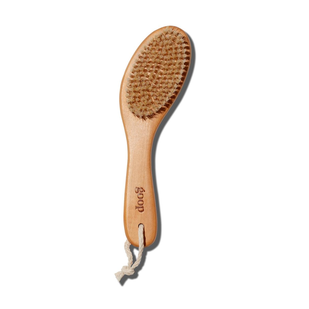 The goop beauty Ultimate Dry Brush with natural bristles and a wooden handle, displayed upright.