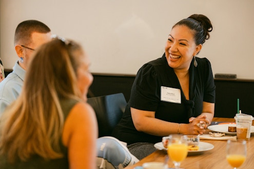 Woman speaking to two other people at a table