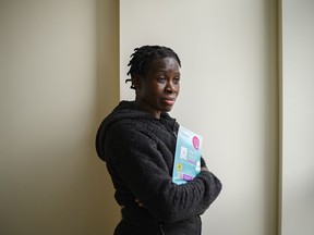 Prossy Luzige, a prevention and linkage coordinator who works in the York Region of Ontario, poses for a photograph with HIV self-test kits, photographed in Toronto, Friday, Feb. 16, 2024.