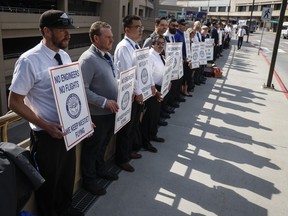 WestJet airplane mechanics stand in a the picket line at Calgary International Airport in Calgary, Saturday, June 29, 2024.THE CANADIAN PRESS/Jeff McIntosh