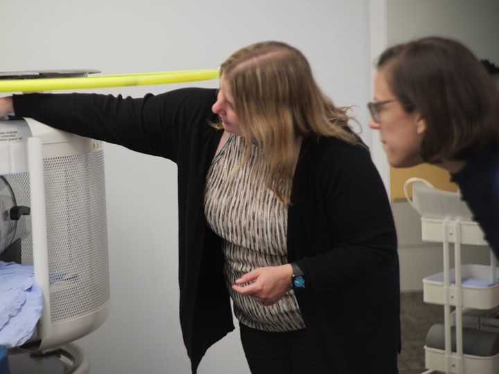  Dr. Kolind explains the ins and outs of portable MRI scanning to our Evaluation and Special Projects Lead Alison Palmer.