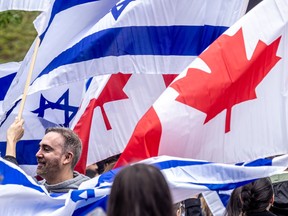 Supporters of Israel are showing carrying large Canadian and Israeli flags.
