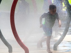 A boy runs through a fountain on a summer day