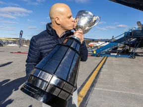 Montreal Alouettes president Mark Weightman kisses the Grey Cup on the tarmac