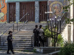 Students look at the doors of the Young Israel of Montreal synagogue in Montreal on May 30 that was recently hit by gunfire.