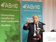 François-Philippe Champagne gestures while speaking at a microphone in front of banners advertising 'FABrIC'