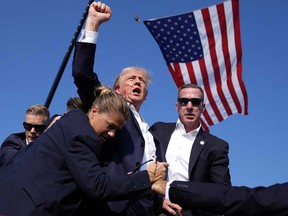Former president Donald Trump is surrounded by U.S. Secret Service agents at a campaign rally, Saturday, July 13, 2024, in Butler, Pa.