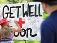 A person writes a message on a Get Well Soon poster board during a vigil for Republican presidential candidate former president Donald Trump at Zeidler Union Square on July 14, 2024 in Milwaukee, Wis.
