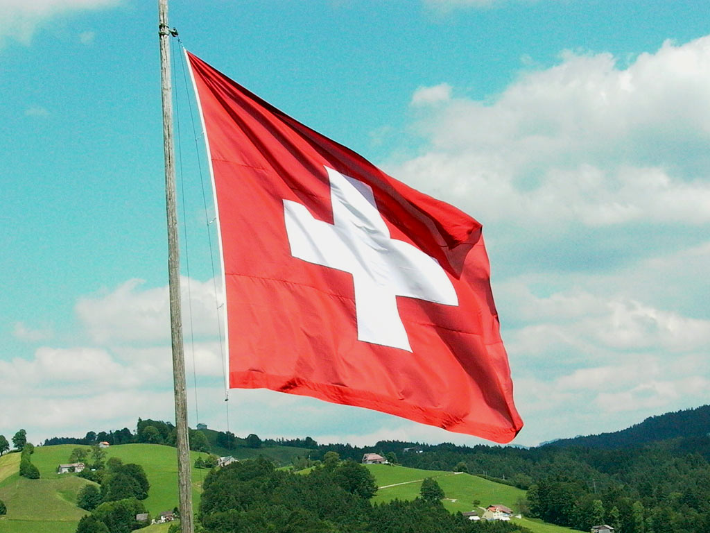 Bandera del país de Suiza ondeando en el horizonte. Imagen usada para graficar oferta de trabajos en Suiza