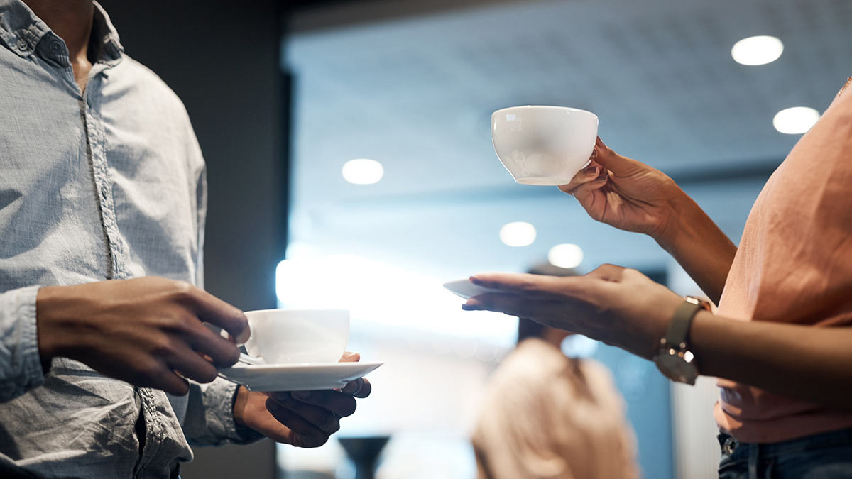 Dos adultos toman café en una entrevista de trabajo