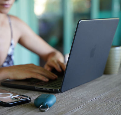 Woman typing on a MacBook with a Speck SmartShell case on it