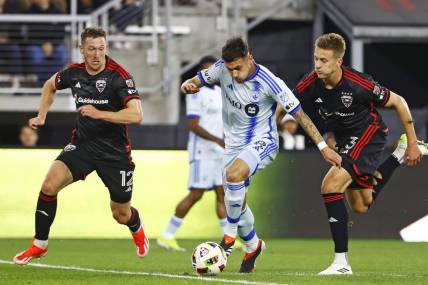 Mar 30, 2024; Washington, District of Columbia, USA; CF Montreal midfielder Dominic Iankov (8) runs with the ball as D.C. United defender Conner Antley (12) and D.C. United defender Lucas Bartlett (3) defend during the first half an at Audi Field. Mandatory Credit: Amber Searls-USA TODAY Sports