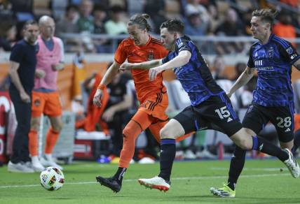 Mar 30, 2024; Houston, Texas, USA; Houston Dynamo FC midfielder Griffin Dorsey (25) attempts to advance the ball as San Jose Earthquakes defender Tanner Beason (15) defends during the second half at Shell Energy Stadium. Mandatory Credit: Troy Taormina-USA TODAY Sports