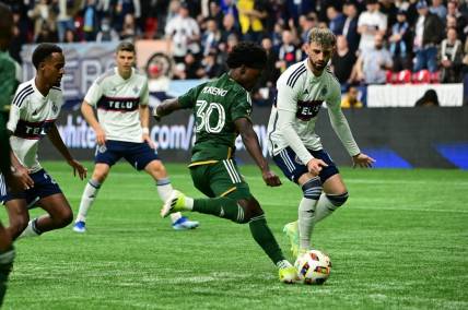 Mar 30, 2024; Vancouver, British Columbia, CAN; Portland Timbers forward Santiago Moreno (30) shoots as Vancouver Whitecaps FC defender Tristan Blackmon (6) defends during the first half at BC Place. Mandatory Credit: Simon Fearn-USA TODAY Sports