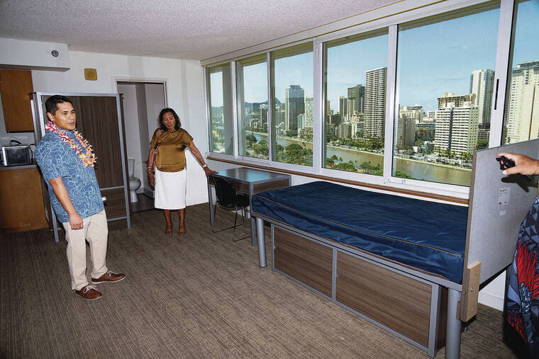 CRAIG T. KOJIMA / CKOJIMA@STARADVERTISER.COM
                                Aedward Los Banos, left, deputy director of the city’s community services, takes a tour of a Waikiki Vista unit.