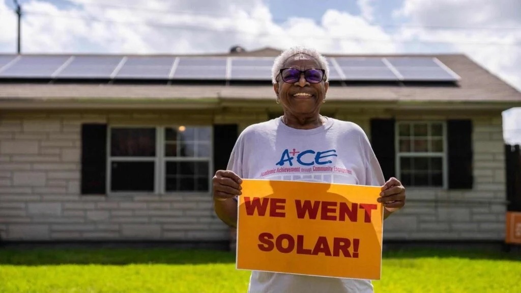 A woman holding a solar energy sign.