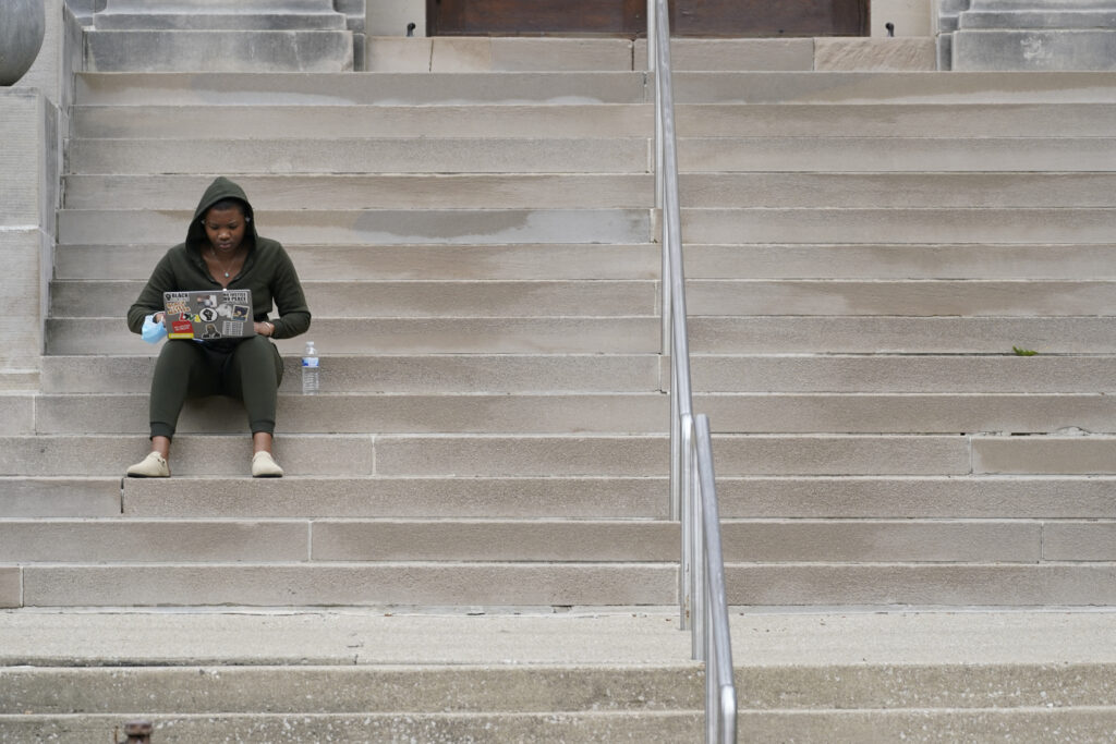 A student sits on the steps at an Indiana university.