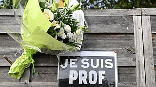 Flowers next to a placard reading "I am a teacher" in tribute to Samuel Paty, the history-geography teacher who was beheaded on Oct. 16, 2020