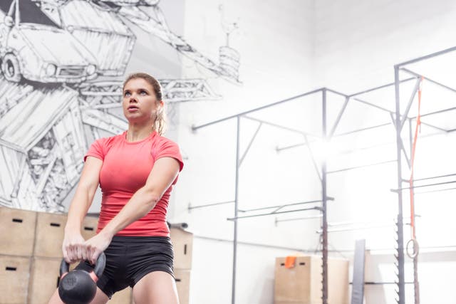 Woman lifting kettlebell in crossfit gym (Alamy/PA)