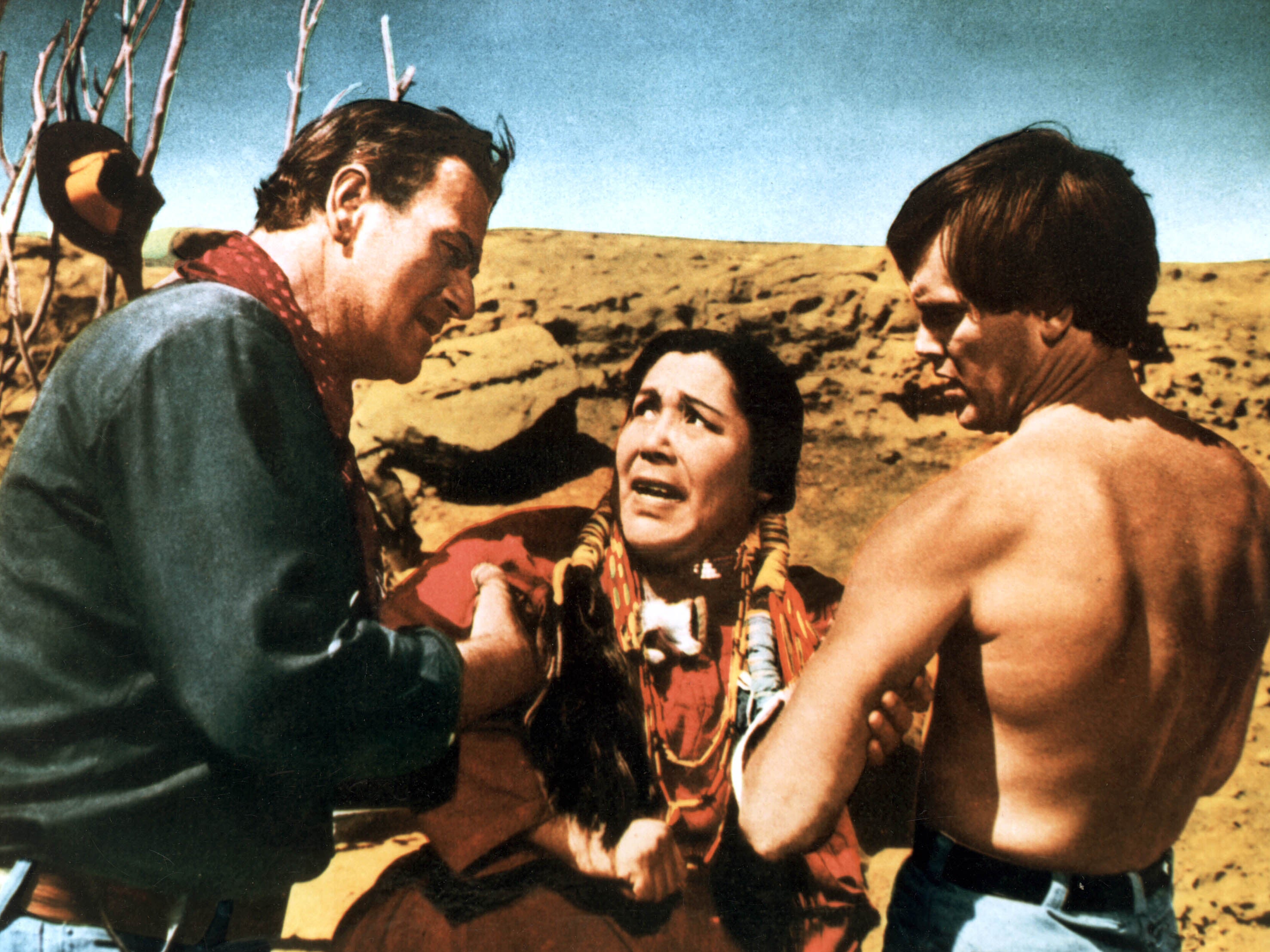 John Wayne as Ethan Edwards and a shirtless Jeffrey Hunter as Martin Pawley holding Beulah Archuletta as Wild Goose Flying in the Night Sky