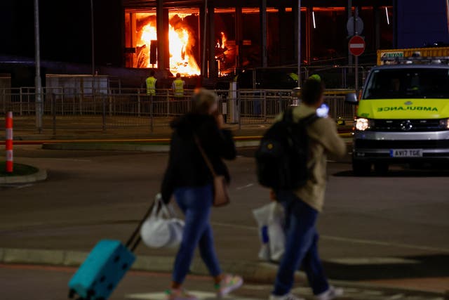 <p>People leave as emergency services respond to a fire in Terminal Car Park 2 at Luton Airport</p>