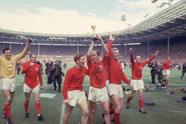 <p>Bobby Charlton, centre, celebrates with the World Cup at Wembley</p>