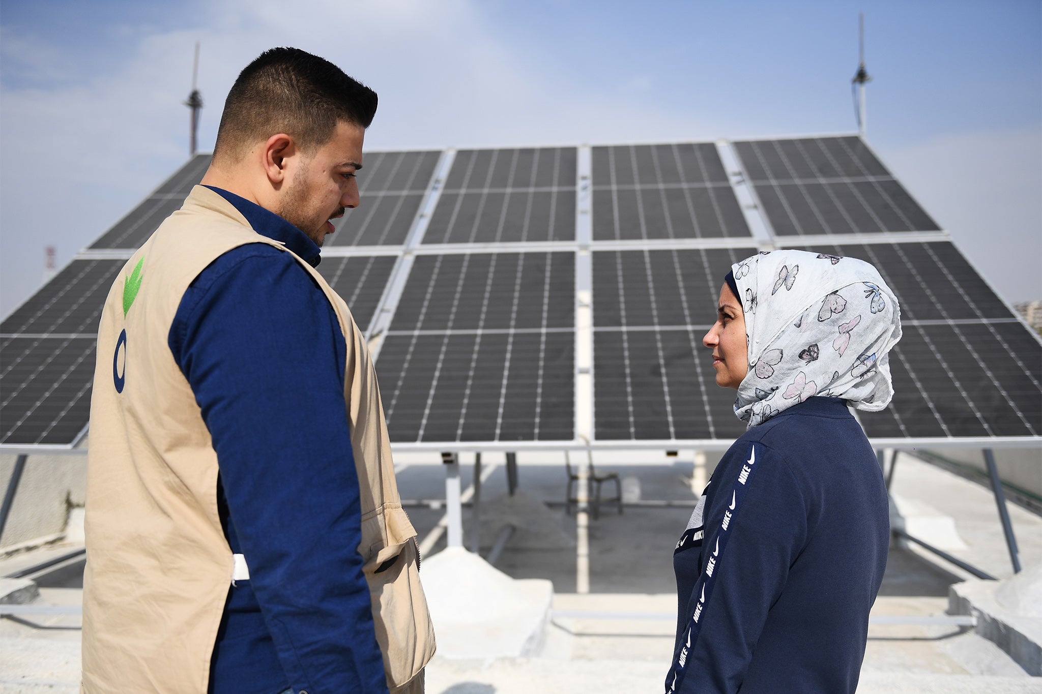 An aid worker from DEC charity Action Against Hunger and the manager of a school working together on a solar electricity project supported by AAH in Aleppo