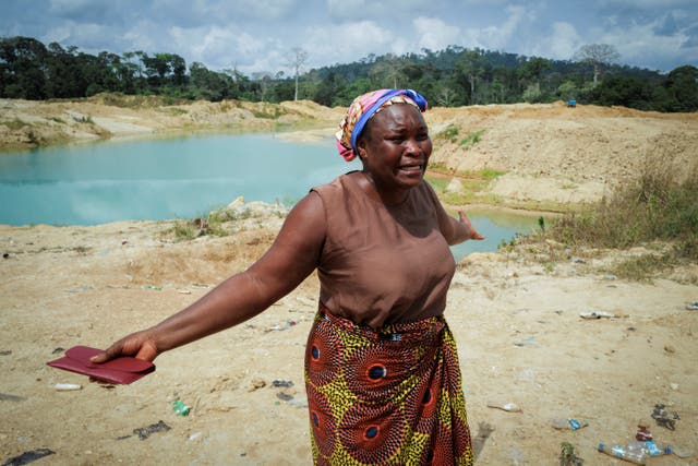 <p>Janet Gyamfi, 52, a cocoa farmer in Ghana, weeps at her plantation which was destroyed by illegal gold mining</p>