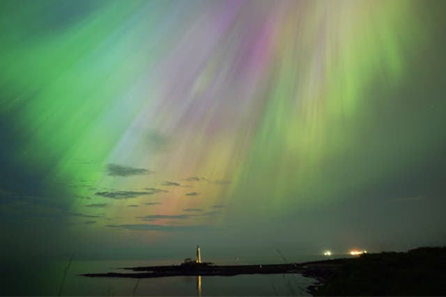 <p>The aurora borealis, also known as the northern lights, glow in the sky over St Mary’s Lighthouse in Whitley Bay on Friday </p>