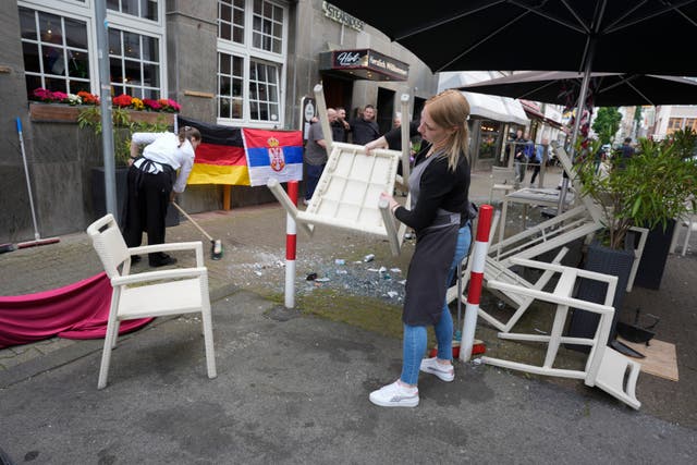 <p>People cleaning up the trash after fans clashes ahead the Group C match between Serbia and England</p>