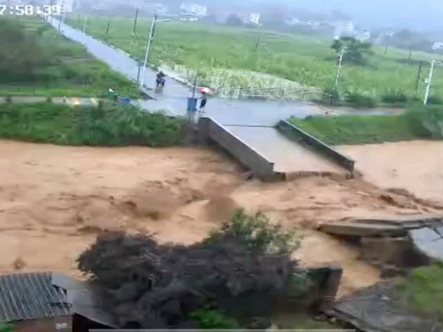 <p>A person stands next to a collapsed bridge following heavy rainfall and flooding in Dongshi Town, Guangdong Province, China</p>