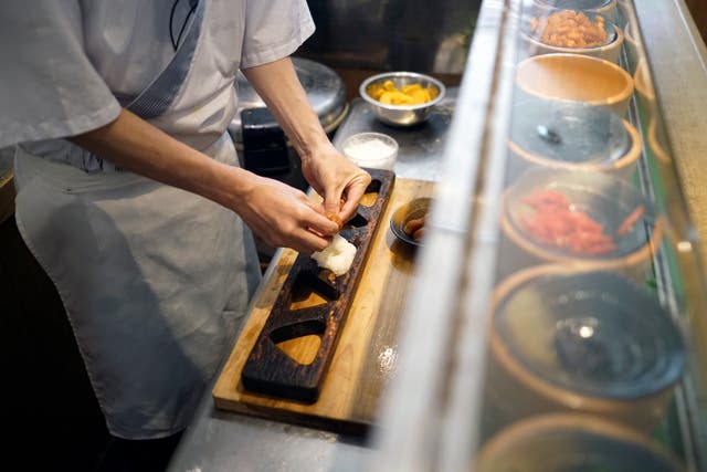 <p>Yosuke Miura makes a rice ball with pieces of grilled salmon at Onigiri Asakusa Yadoroku, Tokyo’s oldest onigiri restaurant </p>
