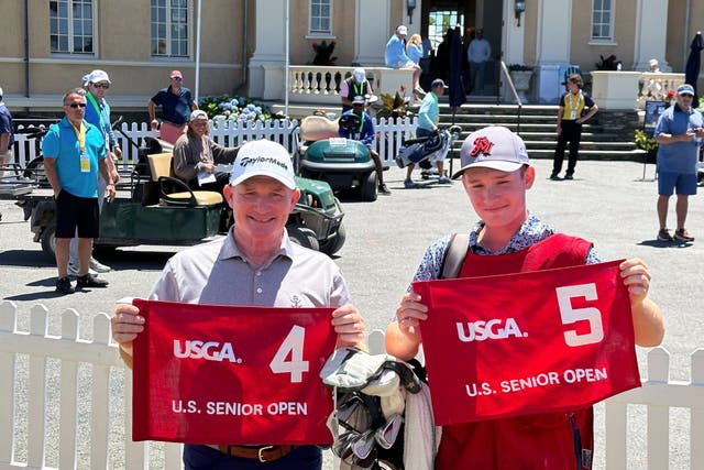 Frank Bensel (left) and his caddie and 14-year-old son, Hagen, pose with flags after Frank’s back-to-back holes-in-one in the US Senior Open (Jimmy Golen/AP)
