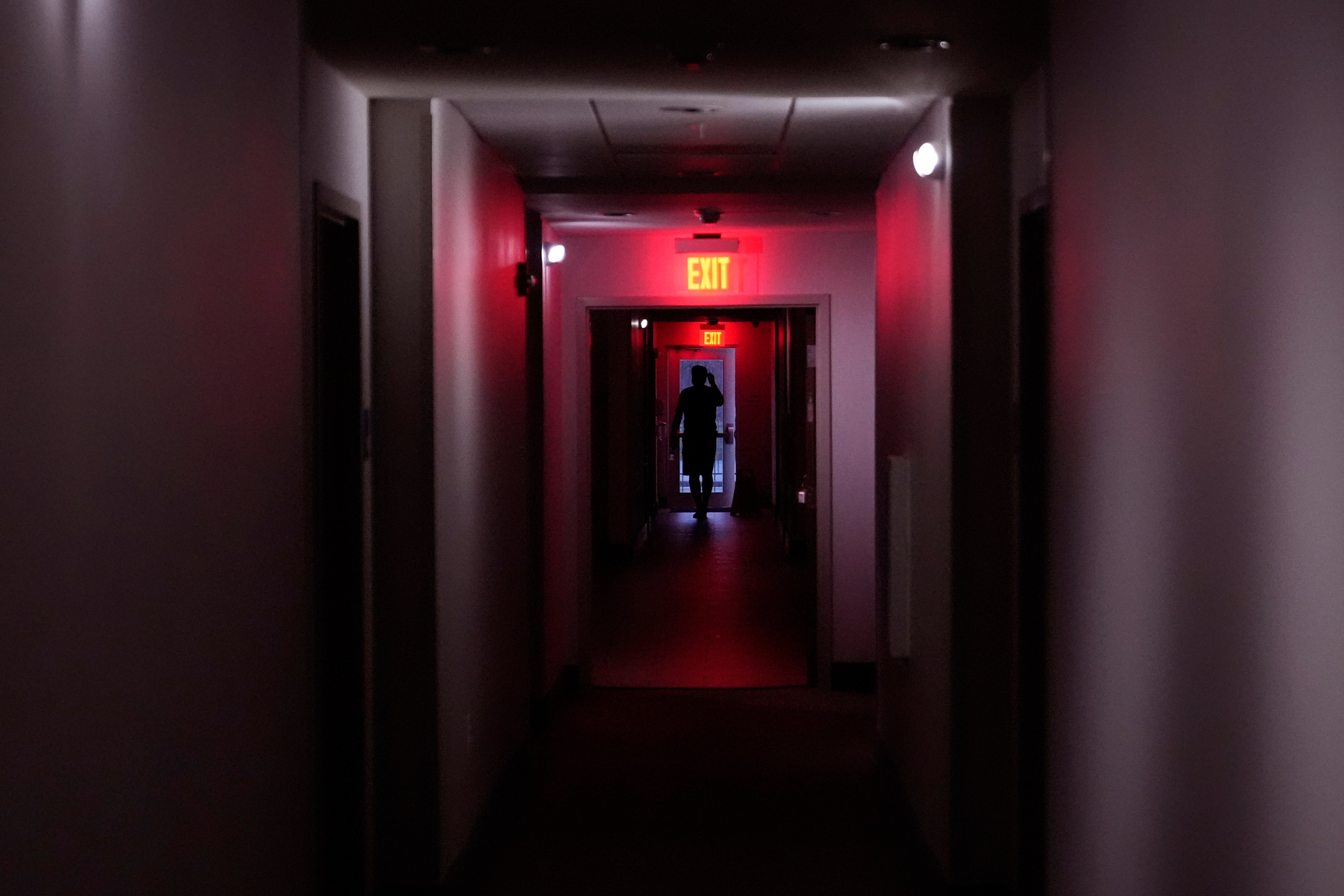 A hotel guest navigates the halls after power was lost due to Hurricane Beryl, Monday, July 8, 2024, in Bay City, Texas