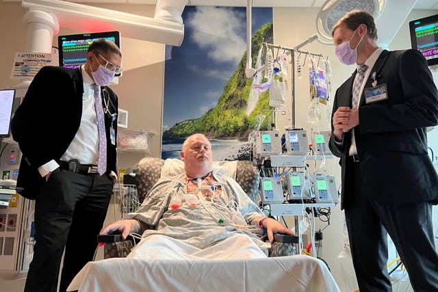 <p>Dr. Girish Mour, left, medical director of Mayo Clinic's Larynx and Trachea Transplant Program, and Dr. David Lott, right, standing on either side of Marty Kedian one week after his transplant surgery in Phoenix, March 8, 2024</p>