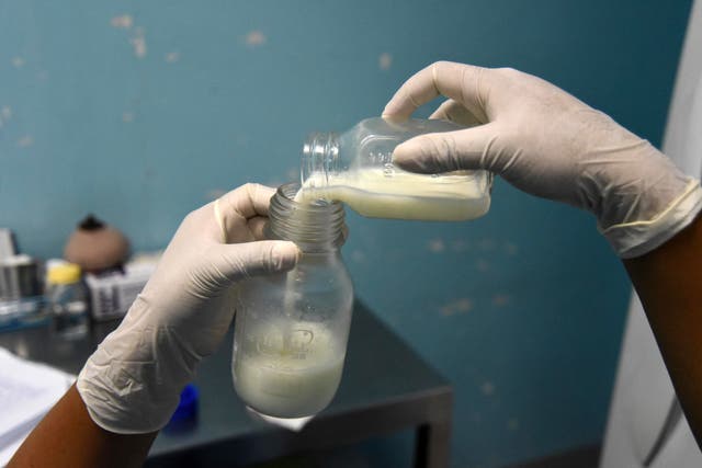 <p>A doctor pours donated breast milk at a milk bank in Guatemala City</p>