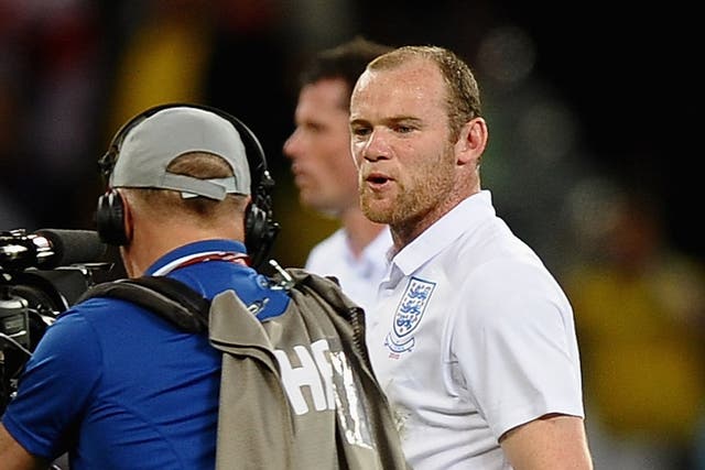 <p>Wayne Rooney of England speaks to a cameraman as he walks off the pitch dejected at the 2010 World Cup</p>