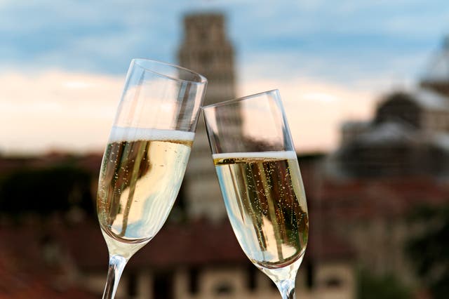 <p>Two glasses of prosecco in front of the Leaning Tower of Pisa </p>