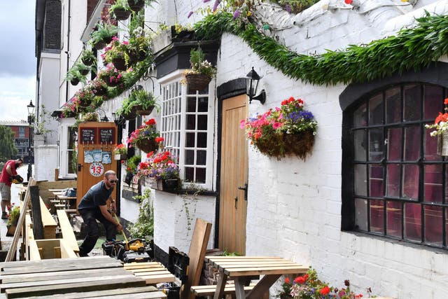 Workers prepare an outdoor seating area at a pub in Birmingham on 2 July, 2020, ahead of "super Saturday".