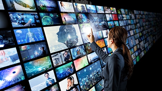 Woman interacting with a wall of monitors