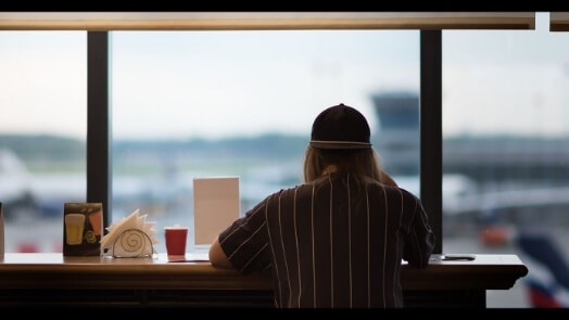 Person looking out window at airport