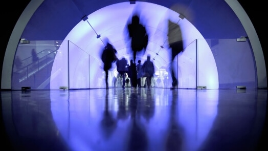 Blurred human figures in a pedestrian walkway tube