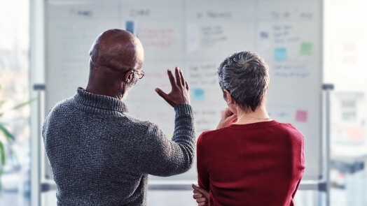 Two people collaborating at a whiteboard