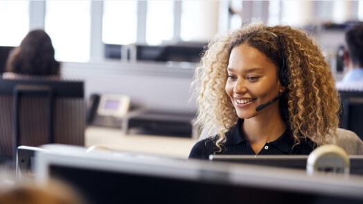 Woman in an office environment wearing a headset