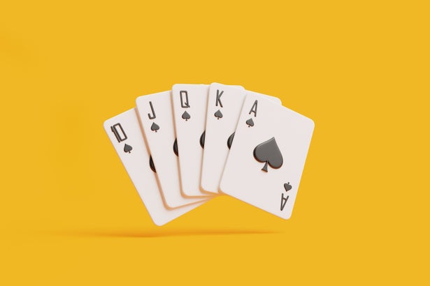 Perfect spade royal flush playing cards spread on a vivid orange background.