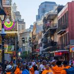 People walking down French Quarter where restaurants and bars are along Bourbon Street in New Orleans.