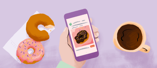 A cup of coffee, two doughnuts and a hand holding a phone that shows an ad for a bakery.