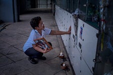 Mary Ann Domingo visiting the tombs of her partner and her son in Caloocan, Philippines. They were fatally shot by the police in 2016, among the thousands to die in extrajudicial killings under murky circumstances during the years that Rodrigo Duterte was president.